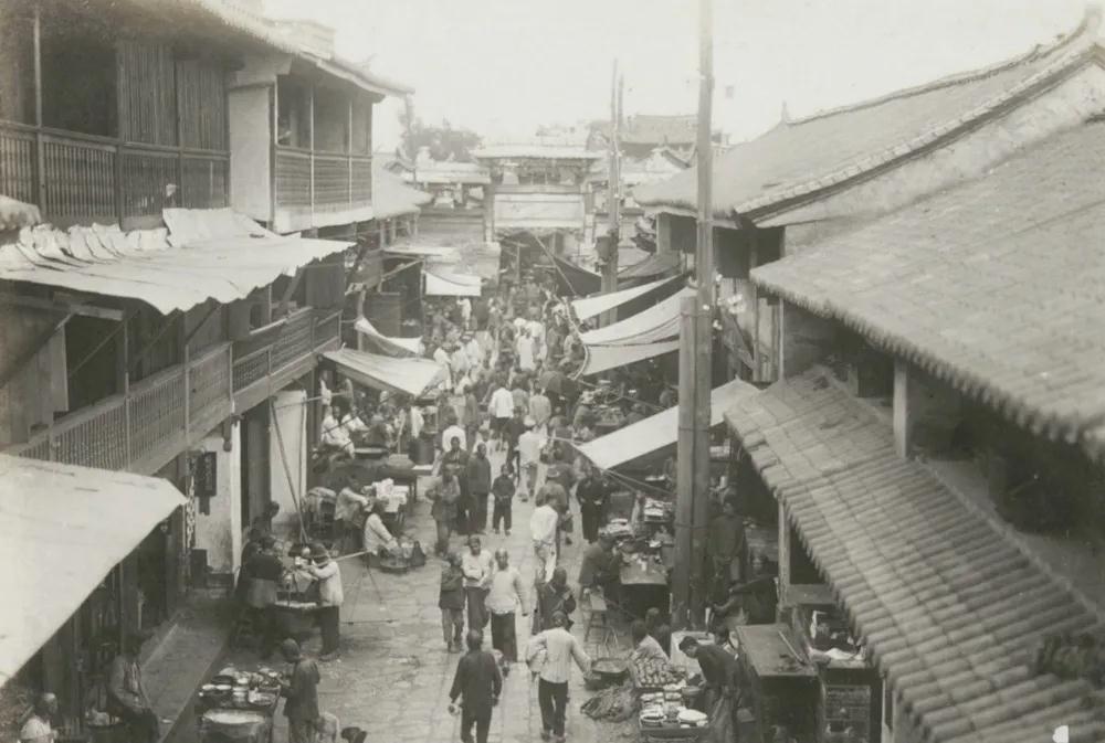1928年，蒙自的街道，临街商铺有两层，行人络绎不绝，很是热闹
